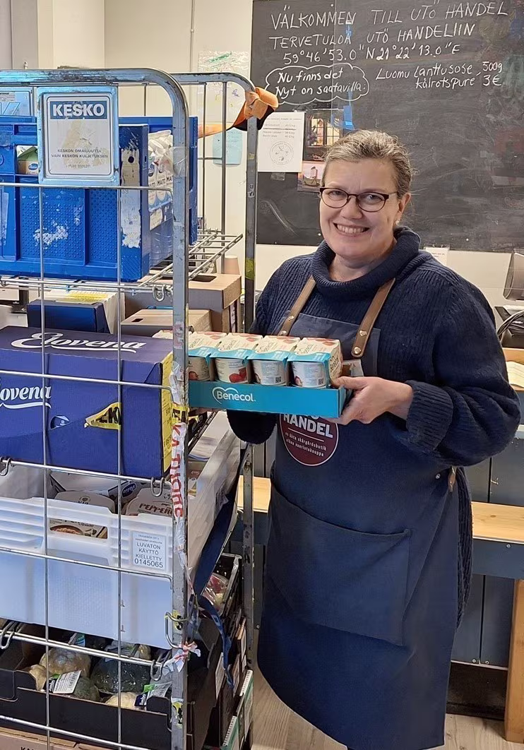 Kaupanhoitaja purkaa kuormaa Utö Handelissa.